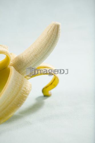 Partly peeled banana sitting up