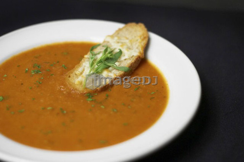 Bowl of Moroccan Spiced Tomato and Fennel Soup with crusty cheese bread