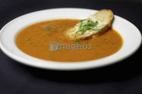 Bowl of Moroccan Spiced Tomato and Fennel Soup with crusty cheese bread