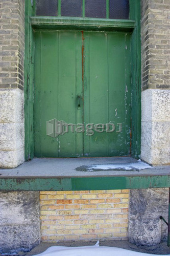 Painted green wooden door of industrial building, Winnipeg, Manitoba