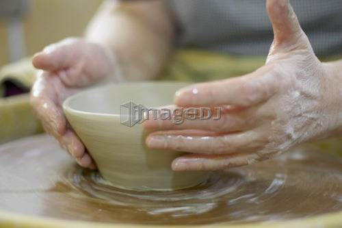 Hands molding a piece of pottery on a wheel-head, Burlington, Ontario