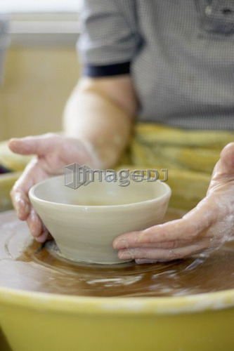 Hands molding a piece of pottery on a wheel-head, Burlington, Ontario