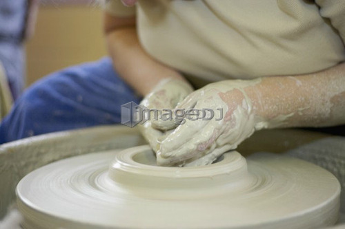Hands molding a piece of pottery on a wheel-head, Burlington, Ontario