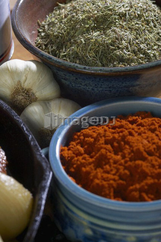 Bowls of paprika and Italian seasoning with whole garlic