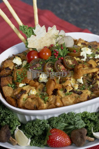 Egg soufflé with wild mushrooms and goat cheese garnished with black cherry tomatoes, breadsticks, kale and strawberries