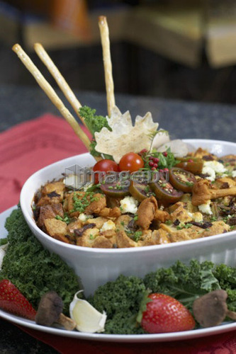 Egg soufflé with wild mushrooms and goat cheese garnished with black cherry tomatoes, breadsticks, kale and strawberries
