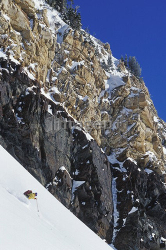 Young man skiing untracked slope in the backcountry near Alta, Utah, USA