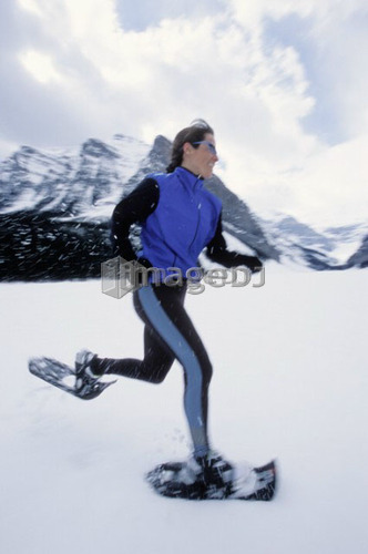 Young woman snowshoeing on Lake Louise, Banff National Park, Alberta, Canada