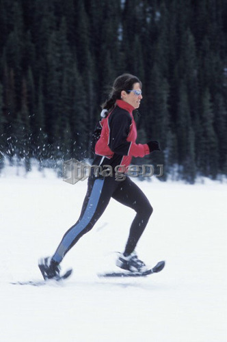 Young woman snowshoeing on Lake Louise, Banff National Park, Alberta, Canada