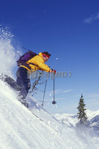 Young man telemarking on steep slope at Fernie Alpine Resort, Fernie, British Columbia, Canada.