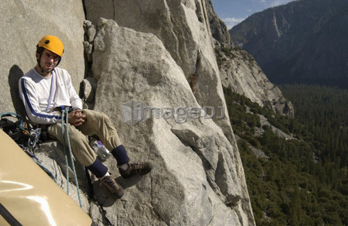 Man (25-30) hanging off a rock ledge on El Capitan in Yosemite National Park, USA