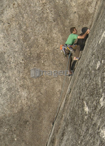 Man (20-25) climbing on a granite rock face, Squamish, B.C.