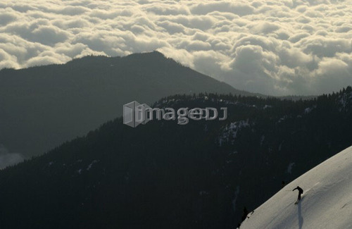 Silhouette of a skier above the clouds with mountain ridges in the background, Mount Arrowsmith, Port Alberni, BC