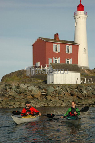 Man (30-35) and woman (25-30) kayaking in front of a lighthouse, Esquimalt, BC