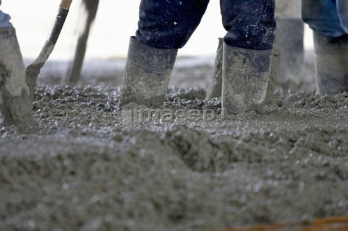 Detail of workers wearing rubber boots in cement; Canada, Ontario, Hamilton(Composting Facility)