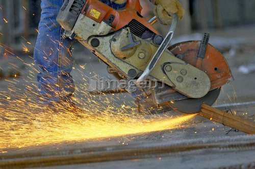 Circular metal saw (chop saw) cutting metal rebar bundle causing sparks; Canada, Ontario, Hamilton (Composting Facility)