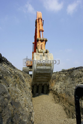 Excavator filling in section of drainage pipe with dirt; Canada, Ontario, Hamilton (Composting Facility)