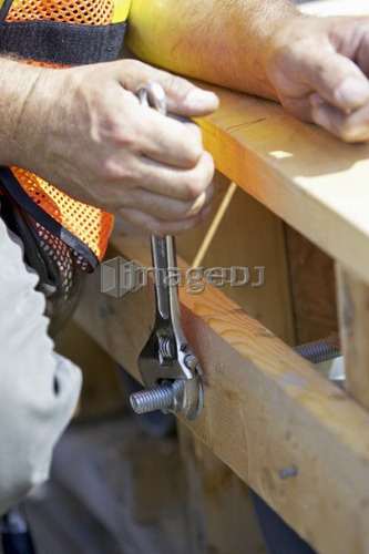 Worker tightening a nut with a wrench; Canada, Ontario, Hamilton (Composting Facility)
