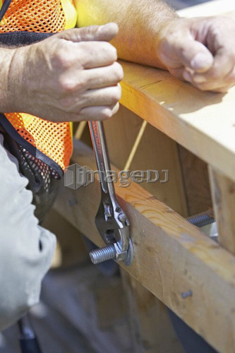 Worker tightening a bolt with a wrench; Canada, Ontario, Hamilton (Composting Facility)