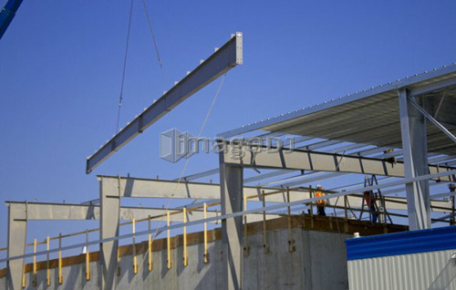 Steel girder being lifted onto roof of building; Canada, Ontario, Hamilton (Composting Facility)
