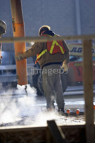 Workers pouring cement into rebar form; Canada, Ontario, Hamilton (Composting Facility)