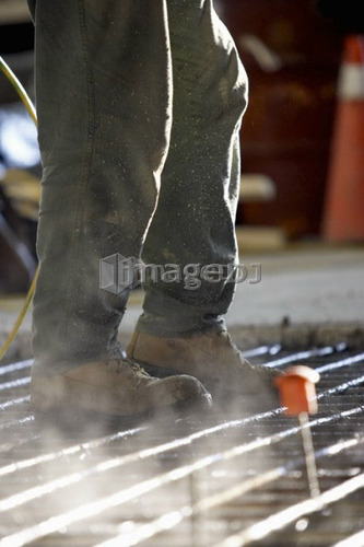 Worker walking on concrete form made of rebar; Canada, Ontario, Hamilton