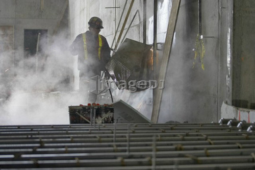 Worker cutting opening in concrete wall; Canada, Ontario, Hamilton (Composting Facility)