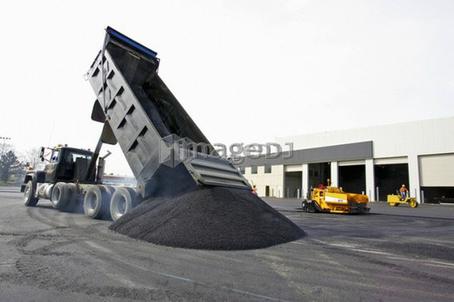 Dump truck dumping a pile of hot asphalt ; Canada, Ontario, Hamilton (Composting Facility)