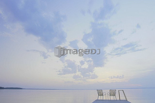 Two folding lawn chairs on dock at Clear Lake; Canada, Manitoba, Riding Mountain National Park