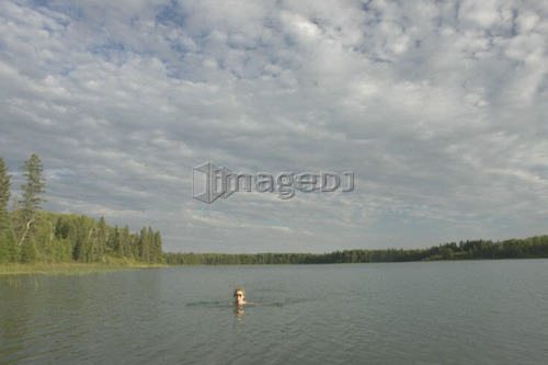 45 year old woman swimming in Katherine L. No motor boats allowed.; Canada, Manitoba, Riding Mountain National Park