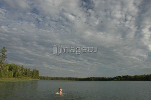 45 year old woman swimming in Katherine Lake. No motor boats allowed.; Canada, Manitoba, Riding Mountain National Park
