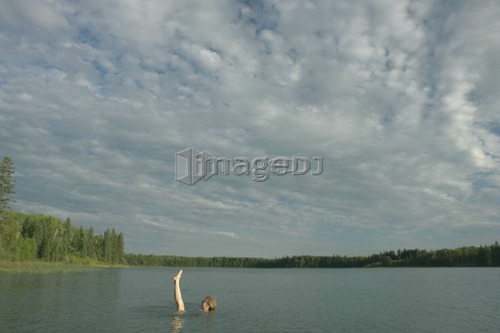 45 year old woman swimming in Katherine Lake. No motor boats allowed.; Canada, Manitoba, Riding Mountain National Park