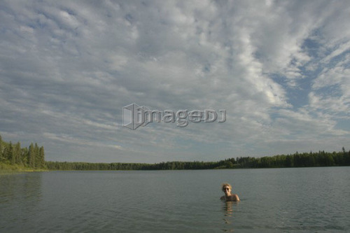 45 year old woman swimming in Katherine Lake. No motor boats allowed.; Canada, Manitoba, Riding Mountain National Park