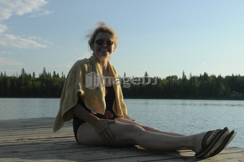45 year old woman on dock, no motors allowed on lake.; Canada, Manitoba, Riding Mountain National Park