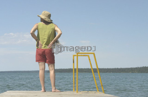 Woman on dock; Canada, Manitoba, Riding Mountain National Park