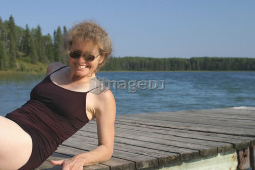 45 year old woman on dock Katherine L.; Canada, Manitoba, Riding Mountain National Park