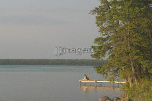 Woman on dock Clear Lake; Canada, Manitoba, Riding Mountain National Park