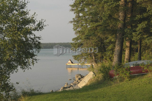 Woman on dock Clear Lake; Canada, Manitoba, Riding Mountain National Park