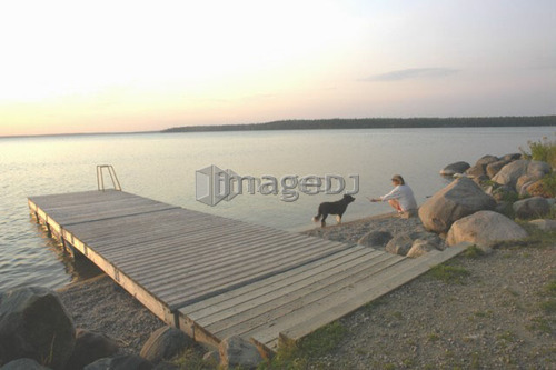 Woman with dog at beach Clear Lake; Canada, Manitoba, Riding Mountain National Park