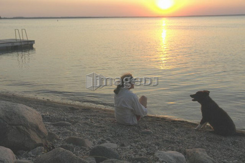 Woman with dog at beach Clear Lake; Canada, Manitoba, Riding Mountain National Park