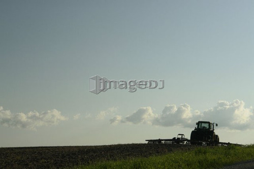 Tractor with cultivator at the edge of a field; Canada, Manitoba, Erickson