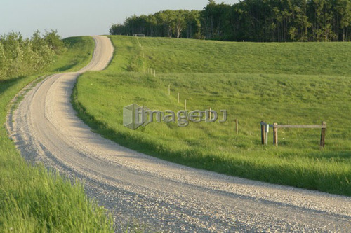Curving gravelled road in countryside; Canada, Manitoba, Erickson
