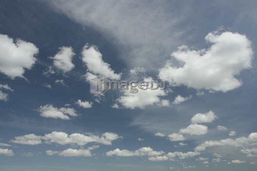 Fluffy clouds in blue sky; Canada, Manitoba, Erickson