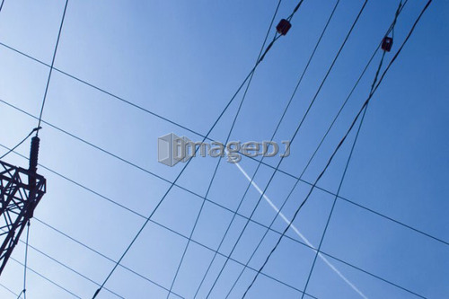 Jet contrail in midst of electric lines; Canada, Ontario