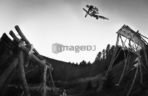 Black and white mountain jumping log jump; Canada, Alberta, Moose Mountain