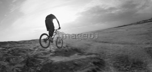 Black and white, youth on mountain bike on prairie terrain; Canada, Alberta, Calgary