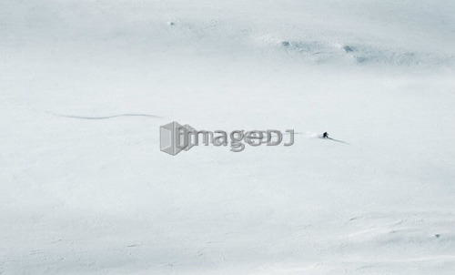 Skier dwarfed by mountain, British Columbia, Rogers Pass