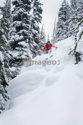 Skier in deep powder; Canada, British Columbia, Rogers Pass