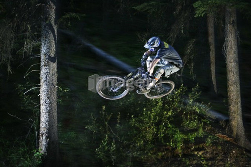 Biker in mid-air at night; Canada, Alberta, Moose Mountain