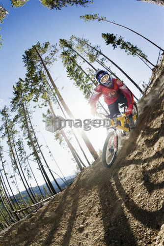 Low angle fish-eye of biker taking a turn; Canada, Alberta, Quirk Creek